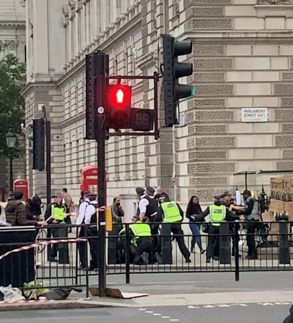 A group of police, including some from the Metropolitan Police’s riot unit, restrain a protester.