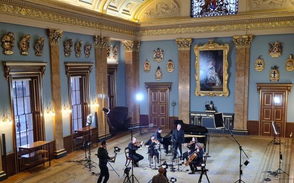 String quartet, grand piano, singer and video crew set up to perform in the beautiful Fish Monger's Hall in London.