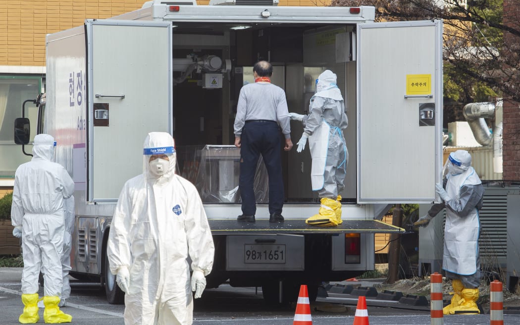 A person with symptoms of suspected coronavirus infection is being examined by hospital personnel at National Medical Center on February 20, 2020 in Seoul, South Korea.