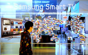 A man walks past a Samsung smart TV advertisment at a showroom in Seoul, South Korea, in 2011.