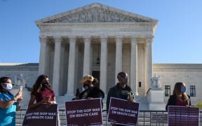 In this file photo taken on 10 November 2020 demonstrators hold signs in front of the US Supreme Court in Washington, DC, as the court opened arguments in the case over the constitutionality of the 2010 Affordable Care Act.