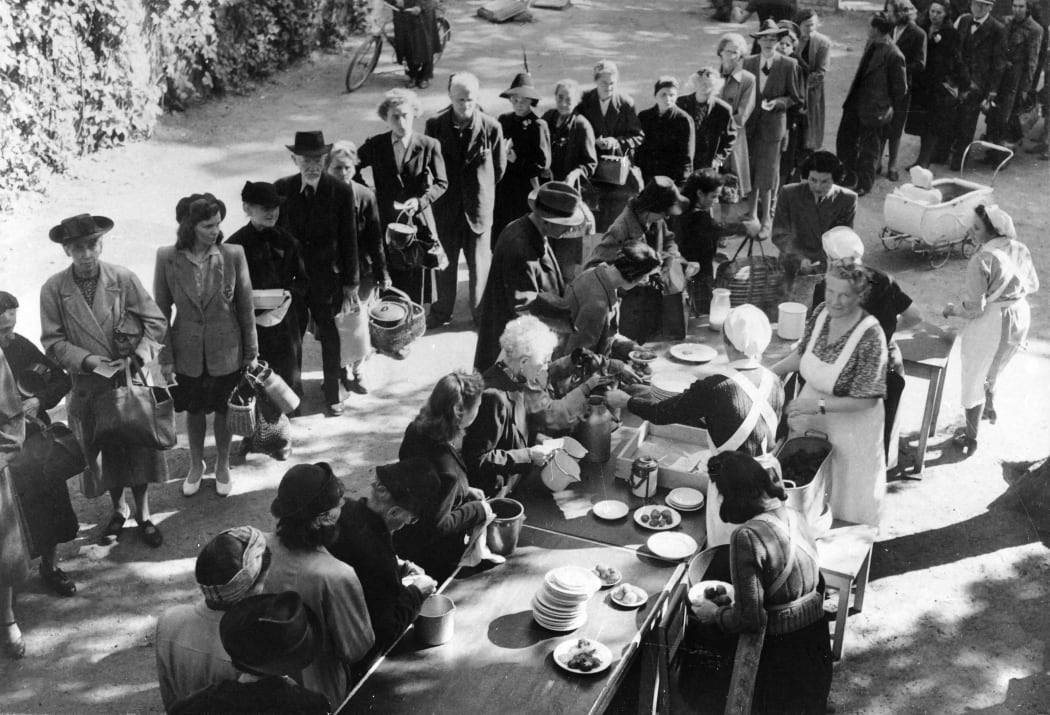 People line up during a food distribution by the German Red Cross, in September 1945 in Berlin.