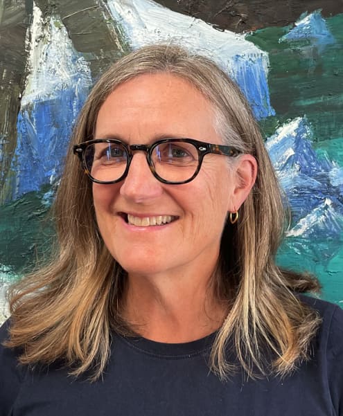 Dr Penelope Jackson is a smiling woman in black-framed glasses with long blonde hair.