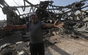 A man inspects the damage to a building after an Israeli strike in the southern town of Kfour, in the Nabatiyeh district, on 17 August 2024, amid the ongoing cross-border clashes between Israeli troops and Hezbollah fighters. Lebanon's health ministry said an Israeli air strike in southern Lebanon killed 10 people including children. It was one of the largest tolls in southern Lebanon since the Iran-backed Hezbollah movement and Israeli forces began exchanging near-daily fire over their border after war in the Gaza Strip began in October. (Photo by Mahmoud ZAYYAT / AFP)