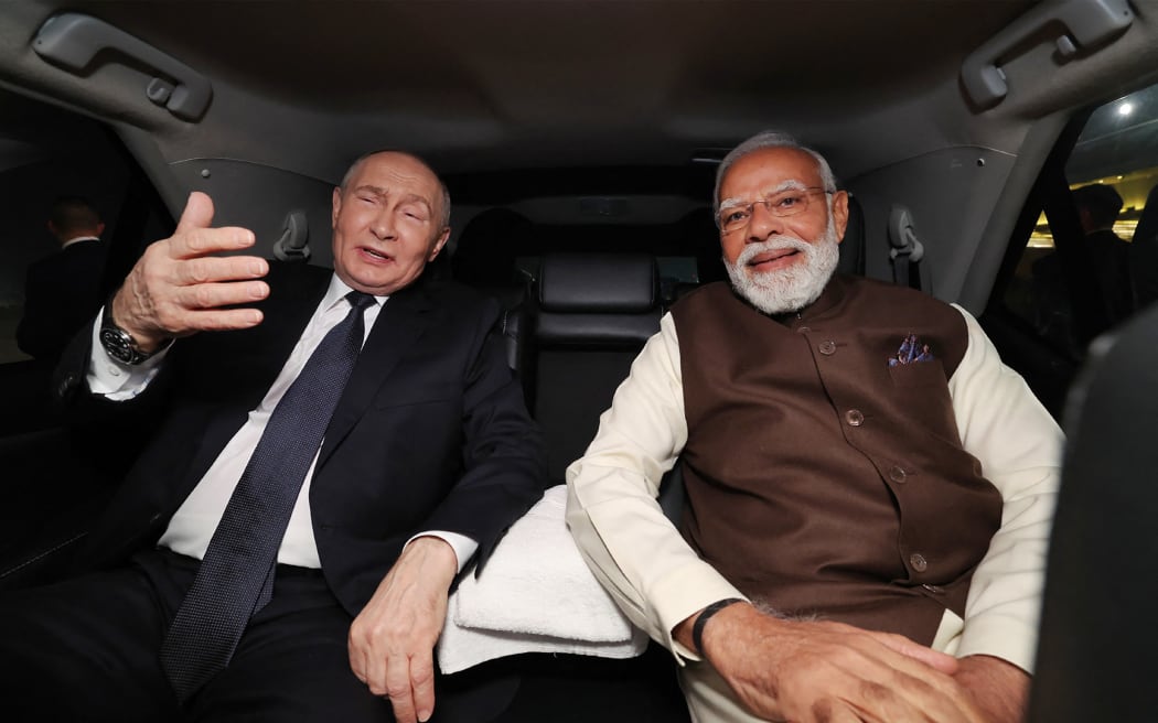 In this handout photograph released by the Indian Press Information Bureau (PIB) on 4 December, 2025, India's Prime Minister Narendra Modi (R) and Russia's President Vladimir Putin sit in a car as they depart Palam Air Force Base after the latter's arrival in New Delhi.