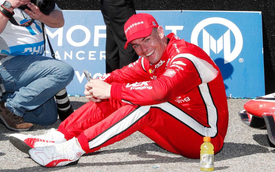 Scott McLaughlin who is exhausted sits on the ground in the winner's circle after winning the Grand Prix of St. Petersburg , 2022.