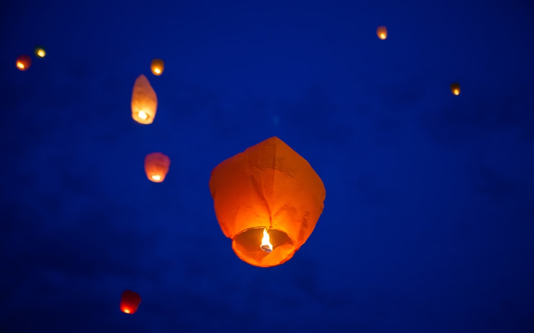 The Chinese lantern flies up highly in the sky. Background.