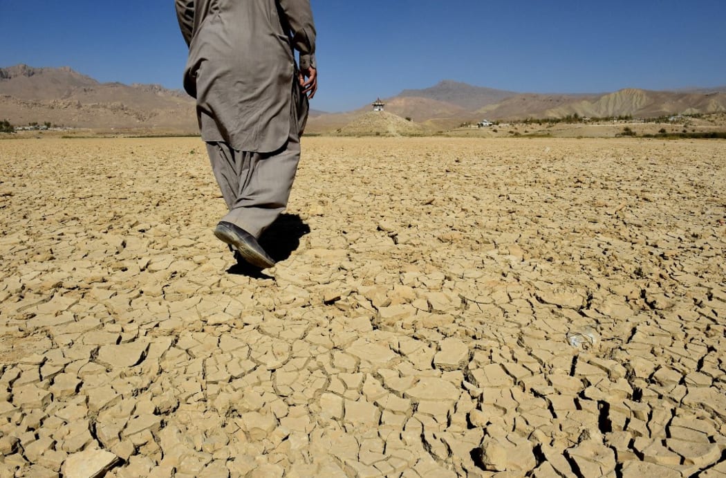A Pakistani villager walks on the cracks of the dry Hanna lake in Urak Valley. The Hanna lake provided water to local people and to the surrounding natural habitat. Some half million people are displaced due to severe drought caused by no rain or less rain.