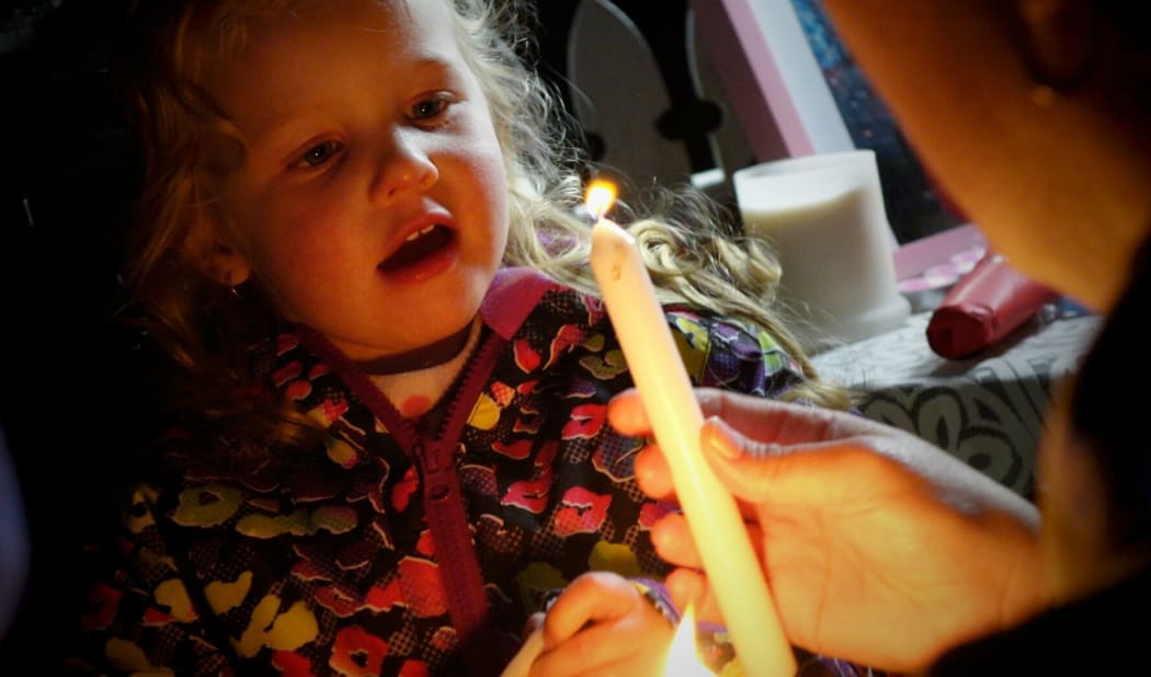 Children light candles at the vigil.