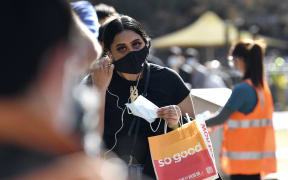 A woman stands waiting to get vaccinated in Sydney.