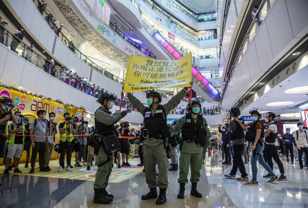 Riot police hold up a warning flag during a demonstration in a mall in Hong Kong on July 6, 2020, in response to a new national security law.