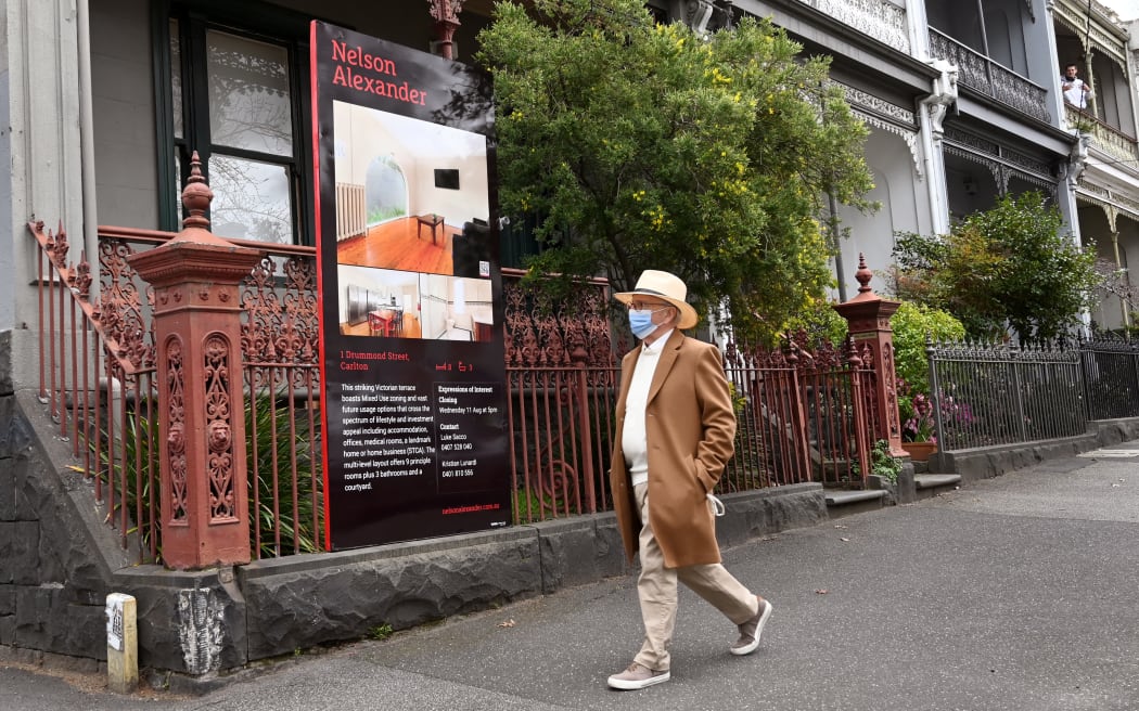 A pedestrian passes a for sale in Melbourne.