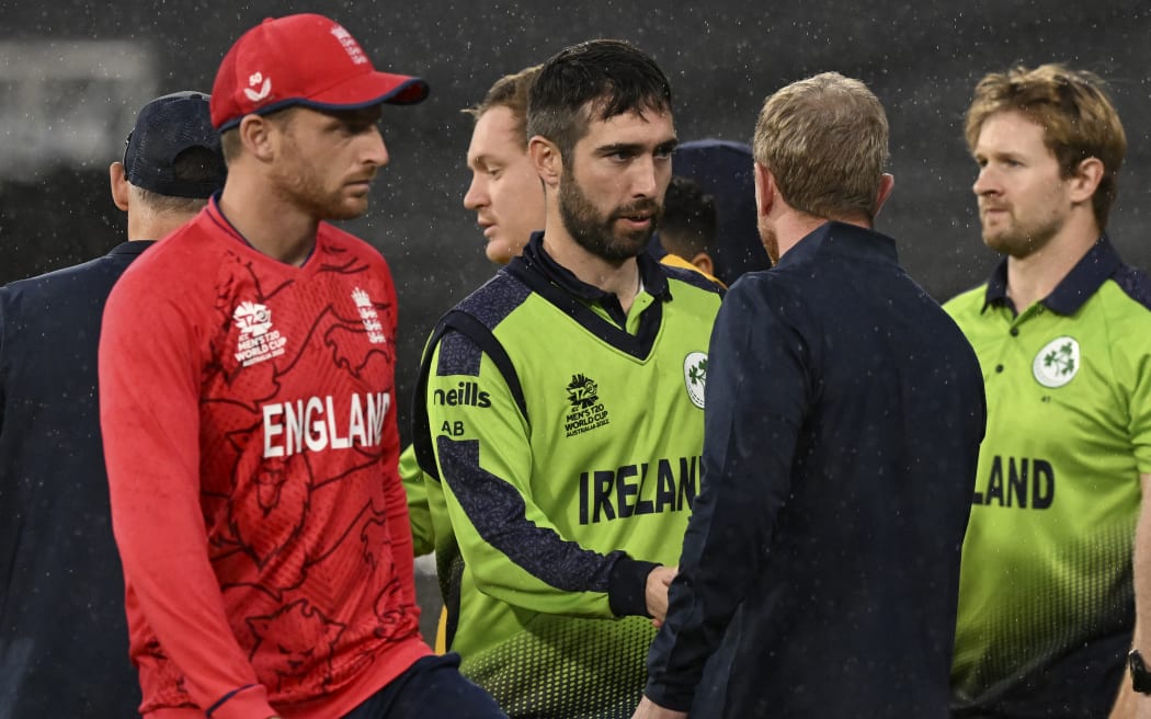 Ireland's Captain Andrew Balbirnie (C) celebrates win with teammates as England's Captain Jos Buttler (L) looks on after the ICC men's Twenty20 World Cup 2022 cricket match between England and Ireland at Melbourne Cricket Ground (MCG) on October 26, 2022 in Melbourne. (Photo by WILLIAM WEST / AFP) / -- IMAGE RESTRICTED TO EDITORIAL USE - STRICTLY NO COMMERCIAL USE --