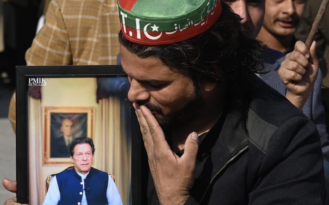 A supporter of the Pakistan Tehreek-e-Insaf (PTI) kisses a portrait of jailed former prime minister and party leader Imran Khan during a protest outside a temporary election commission office in Peshawar on February 10, 2024, amid claims the election result delay is allowing authorities to rig the vote-counting. A delayed count is underway after Pakistan's election on February 8, with candidates backed by Imran Khan's Pakistan Tehreek-e-Insaf (PTI) faring better than expected despite a crackdown targeting the party. (Photo by Abdul Majeed AFP photographer / AFP)