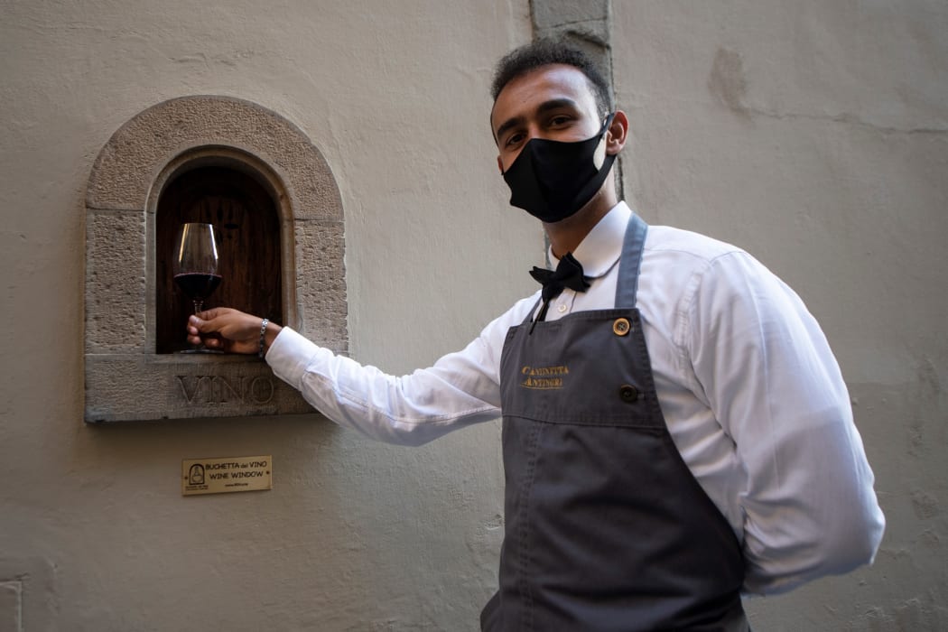 A waiter in Florence with a "buchetta del vino", a small window used to serve wine. As 16th-century Florentines dropped like flies to the plague, survivors drowned their fears in wine, passed to them through the windows which are enjoying a renaissance during the coronavirus.