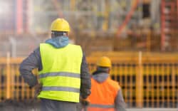 Two builders in yellow and orange at the construction site