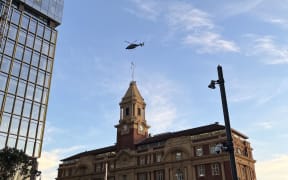 A police helicopter flies above Auckland's CBD as armed police respond to a serious incident.
