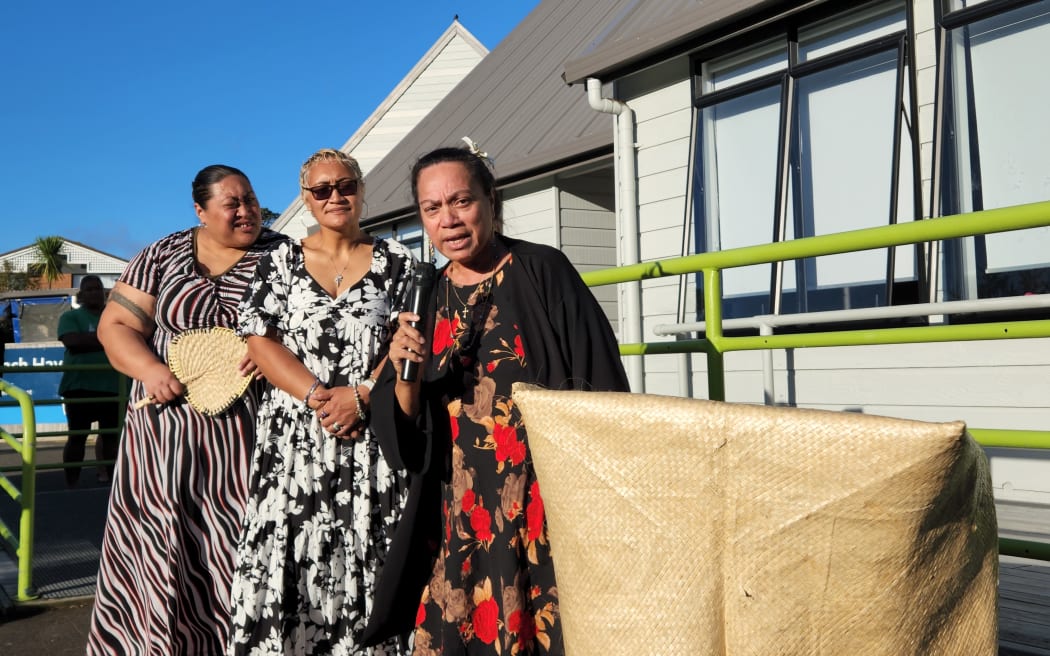Church leader and chairperson of the North Shore Pasifika Forum, Emi Suaniu, right, leads a Samoan song of blessing at a community gathering to pay tribute to a local man who died in a fatal assault on Friday.