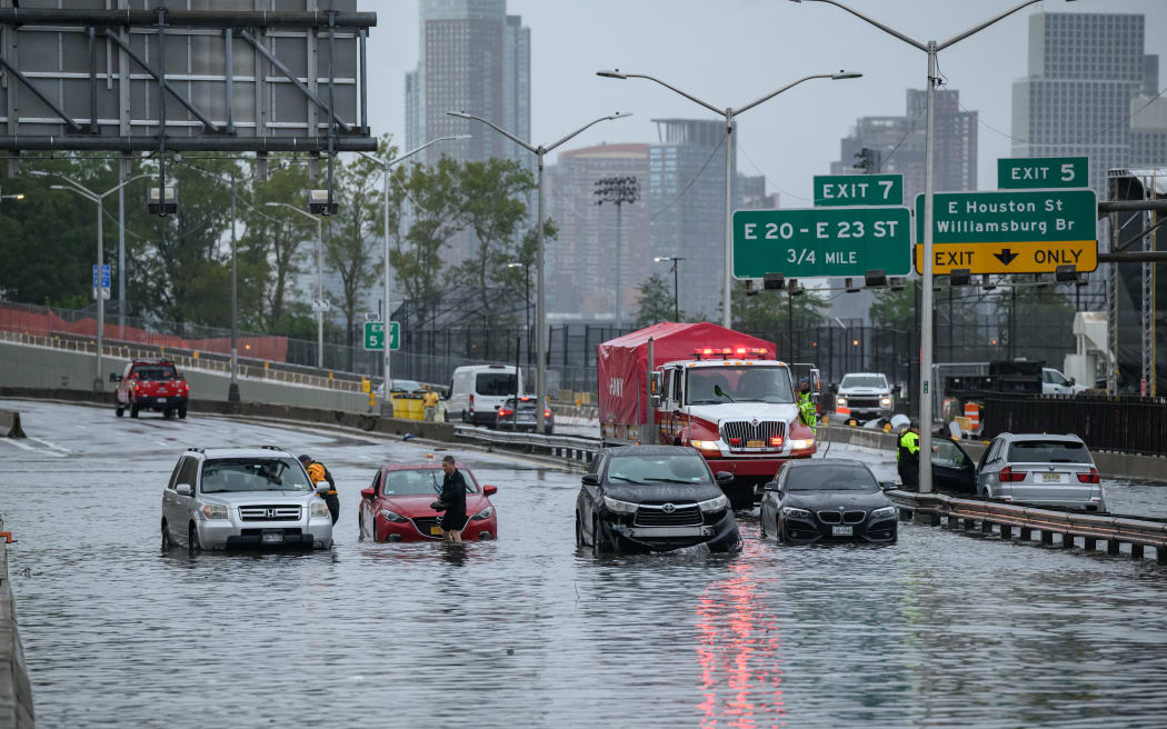 Cars in floodwater on the FDR highway in Manhattan, New York on September 29, 2023. Heavy rains overnight in the northeastern United States left parts of New York City under water on Friday, partially paralyzing subways and airports in the country's financial capital. (Photo by Ed JONES / AFP)