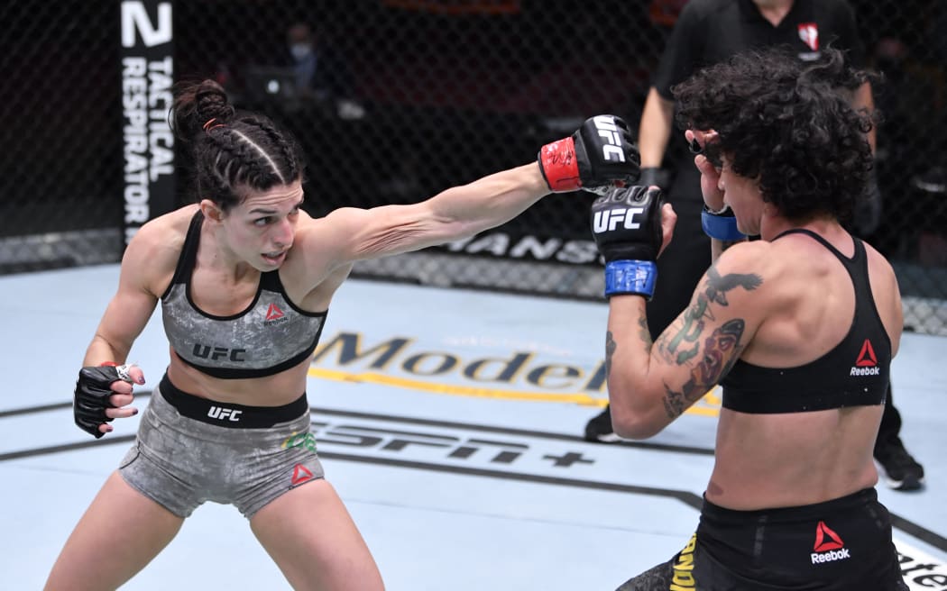LAS VEGAS, NEVADA - DECEMBER 12: In this handout image provided by UFC, (L-R) Mackenzie Dern punches Virna Jandiroba of Brazil in their women's strawweight bout during the UFC 256 event at UFC APEX on December 12, 2020 in Las Vegas, Nevada.   Jeff Bottari/Zuffa LLC via Getty Images/AFP (Photo by Handout / GETTY IMAGES NORTH AMERICA / Getty Images via AFP)