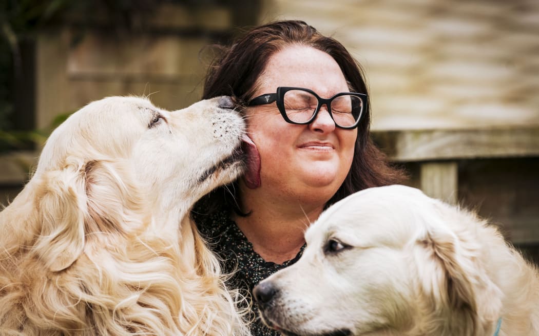 15082024 Haber Fotoğrafı VANESSA LAURIE/STUFF Lydia Freer, 4 Ağustos Cumartesi günü Okura yakınlarındaki Weld Road'da Timaru nehrinde mahsur kaldı. Golden Retriever Archie'nin içinde telefonunun bulunduğu ceketi getirmesinin ardından polis tarafından kurtarıldı. Resimde Lydia Freer ve köpekleri Blue (solda) ve Archie görülüyor.