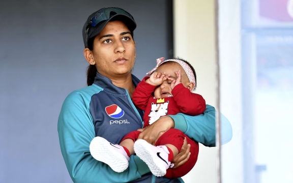 Pakistan's Iram Javed takes care of her teammate Bismah Maroof's daughter Fathima in the pavilion during the Women's Cricket World Cup match between New Zealand and Pakistan at Hagley Oval in Christchurch in 2022.