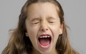 Studio portrait of a little girl yelling.