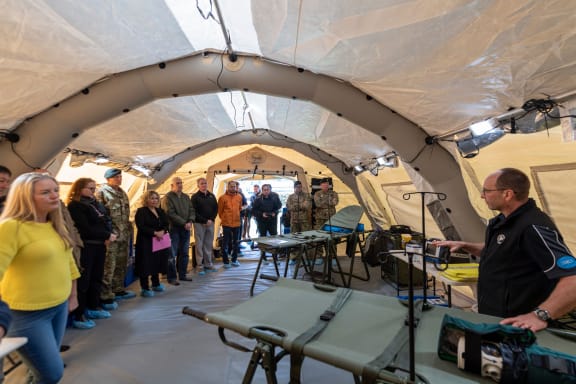 The New Zealand Medical Assistance Team's Dr Alan Goodey explaining the inner workings of the triage area in the deployable health facility setup.  27 October 2023 Trentham Military Base, Upper Hutt, Wellington.