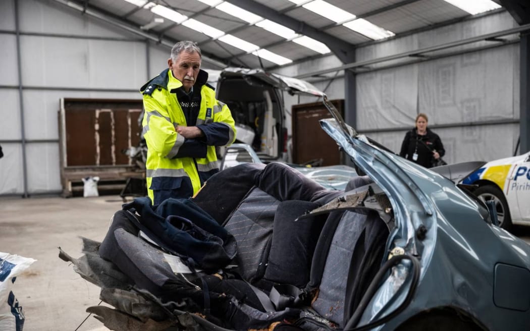 Police with the car, which snapped in half in the 6 August 2021 fatal crash outside Timaru.
