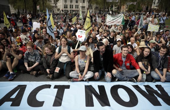 Protesters sit in the road in Parliament Square, in London, on 23 April, 2019, during a climate protest.
