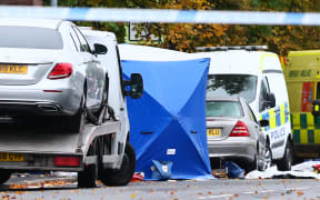 Police tents cover parts of the scene on the main road outside Heaton Park Hebrew Congregation synagogue in Crumpsall, north Manchester, on 3 October, 2025, following an attack at the synagogue the day before.