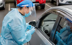 A health worker conducts a test at a COVID-19 coronavirus testing centre in the suburb of Northcote in Auckland on August 12, 2020.
