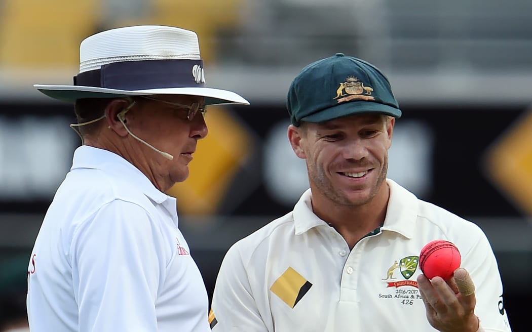 Australia's fielder David Warner (right0 discusses the ball's shape with umpire Ian Gould during a test match between Australia and Pakistan 2016.
