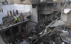 Security personnel search for victims in the wreckage of a Pakistan International Airlines aircraft after it crashed in a residential area in Karachi.