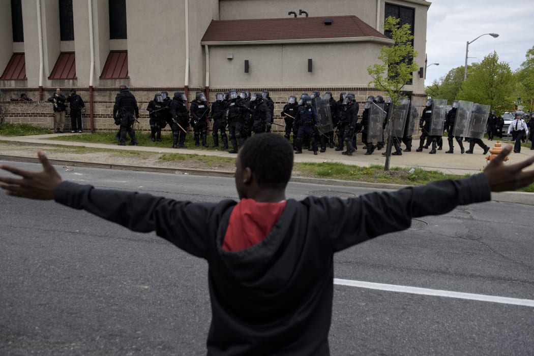 Baltimore police officers form a line in front of protesters in the streets near Mondawmin Mall April 27, 2015 in Baltimore, Maryland.