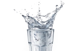 Glass full of water with splash. Isolated on white background. (Photo by LEONELLO CALVETTI/SCIENCE PHOTO / LCL / Science Photo Library via AFP)