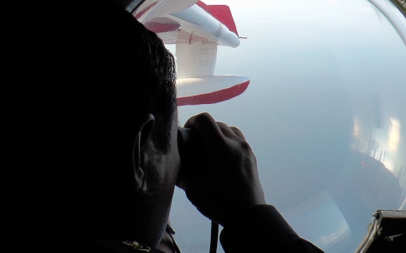 Malaysian maritime personnel searching for the missing Malaysia Airlines plane off the northeastern coast of Malaysia.