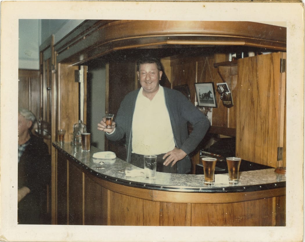 1970s bar tender holding beer