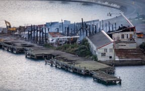 Fire crews dampen down the site of a blaze in a warehouse at Shelly Bay, Wellington.