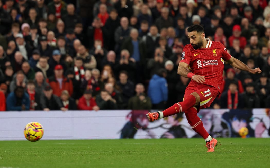 Liverpool striker Mohamed Salah shoots from the penalty spot to score the team's second goal against Manchester City at Anfield. Dec 2024.