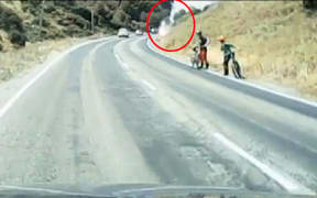 Dash-cam footage showing two cyclists looking back towards smoke.