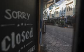 A closure sign is displayed on a shop in an empty street in Christchurch, New Zealand, on April 16, 2020.