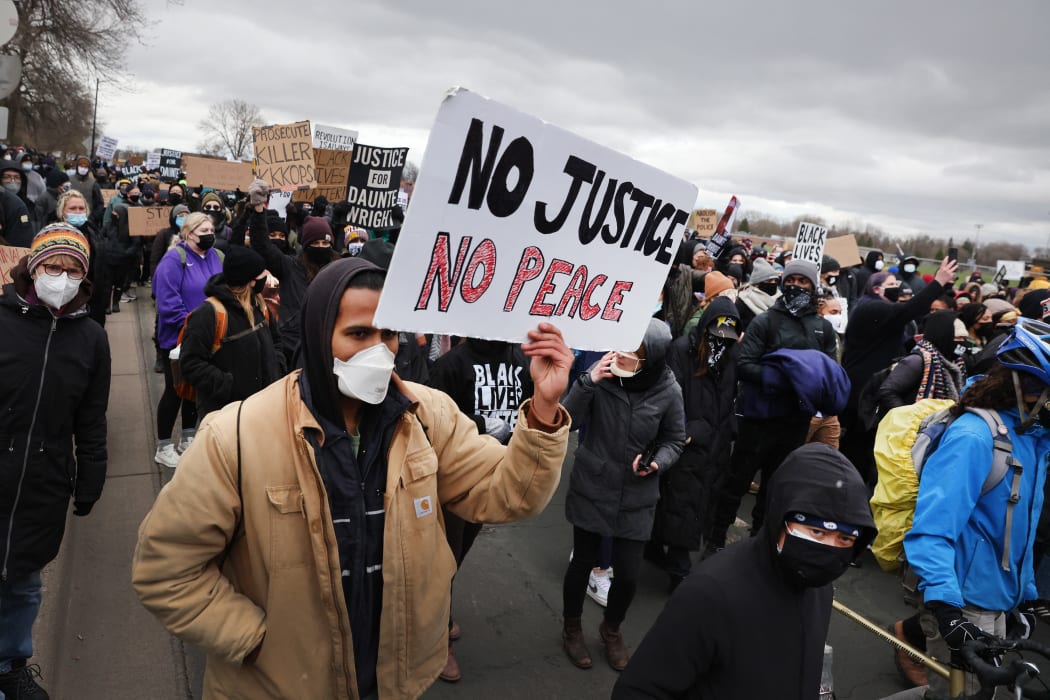 Demonstrators protesting the shooting death of Daunte Wright march to the FBI offices from the Brooklyn Center police station on 13 April 2021 in Brooklyn Center, Minnesota.