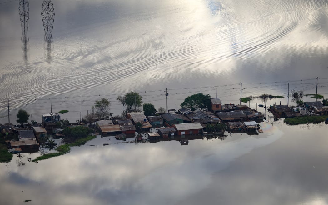 An aerial view shows a flooded street of Industrial neighborhood in the city of Eldorado do Sul, Rio Grande do Sul state, Brazil, on May 20, 2024. More than 600,000 people have been displaced by the heavy rain, flooding and mudslides that have ravaged the south of the state of Rio Grande do Sul for around two weeks. (Photo by Anselmo Cunha / AFP)