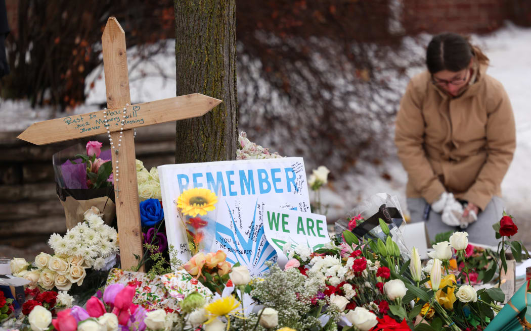 People gather at a makeshift memorial for 37-year-old Renee Nicole Good, who was shot and killed at point blank range on January 7 by a US Immigration and Customs Enforcement (ICE) agent as she apparently tried to drive away from agents who were crowding around her car, in Minneapolis, Minnesota, on January 8, 2026. A US Immigration and Customs Enforcement (ICE) agent shot and killed an American woman on the streets of Minneapolis January 7, leading to huge protests and outrage from local leaders who rejected White House claims she was a domestic terrorist. (Photo by CHARLY TRIBALLEAU / AFP)
