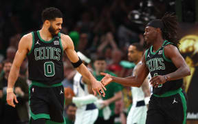 Jayson Tatum #0 and Jrue Holiday #4 of the Boston Celtics high five during the third quarter of their win over the Dallas Mavericks in Game Two of the NBA Finals.