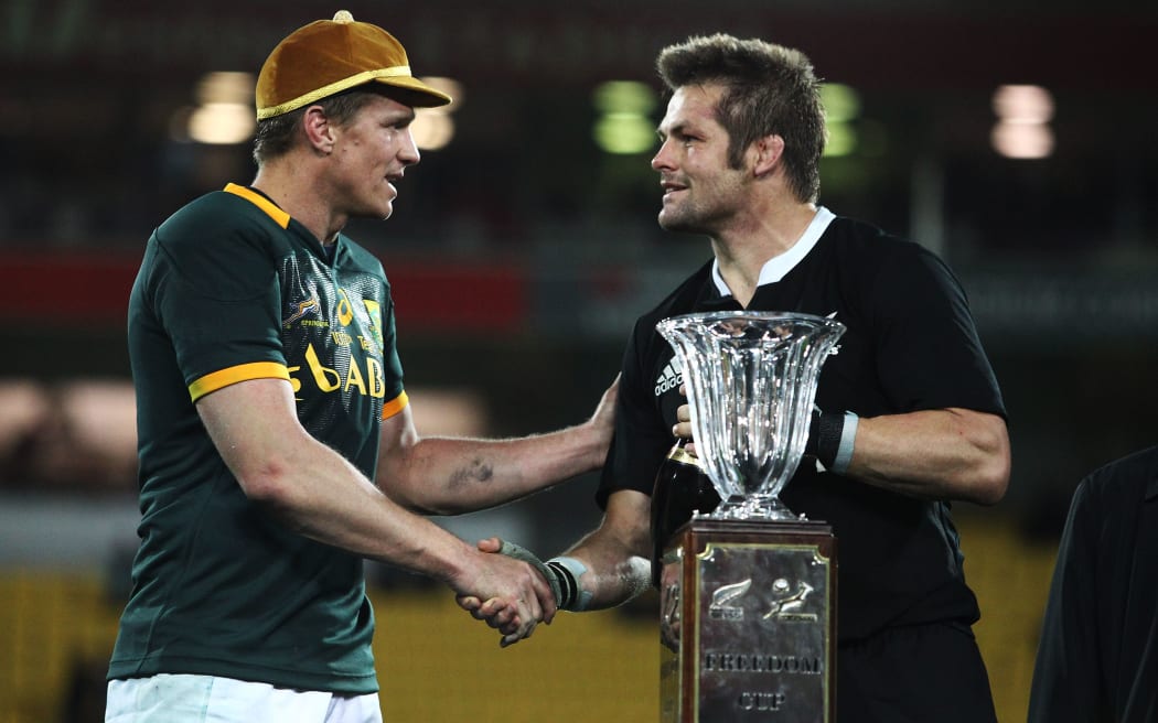 All Blacks captain Richie McCaw congratulates South African captain Jean de Villiers on his 100th Test cap after the All Blacks 14-10 win in Wellington 2014.