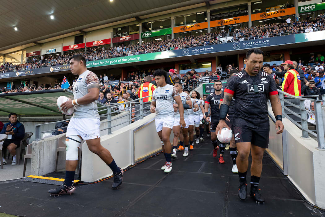 Moana Pasifika captain Michael Alaalatoa and Māori All Blacks captain Ash Dixon lead their team out to the field before the rugby match at FMG Stadium, Hamilton, New Zealand.