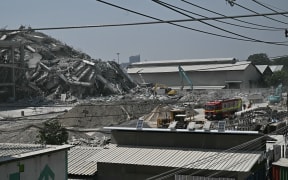 A collapsed building at a construction site is seen in Bangkok on March 28, 2025, after an earthquake. A powerful earthquake rocked central Myanmar on March 28, buckling roads in capital Naypyidaw, damaging buildings and forcing people to flee into the streets in neighbouring Thailand. (Photo by Lillian SUWANRUMPHA / AFP)