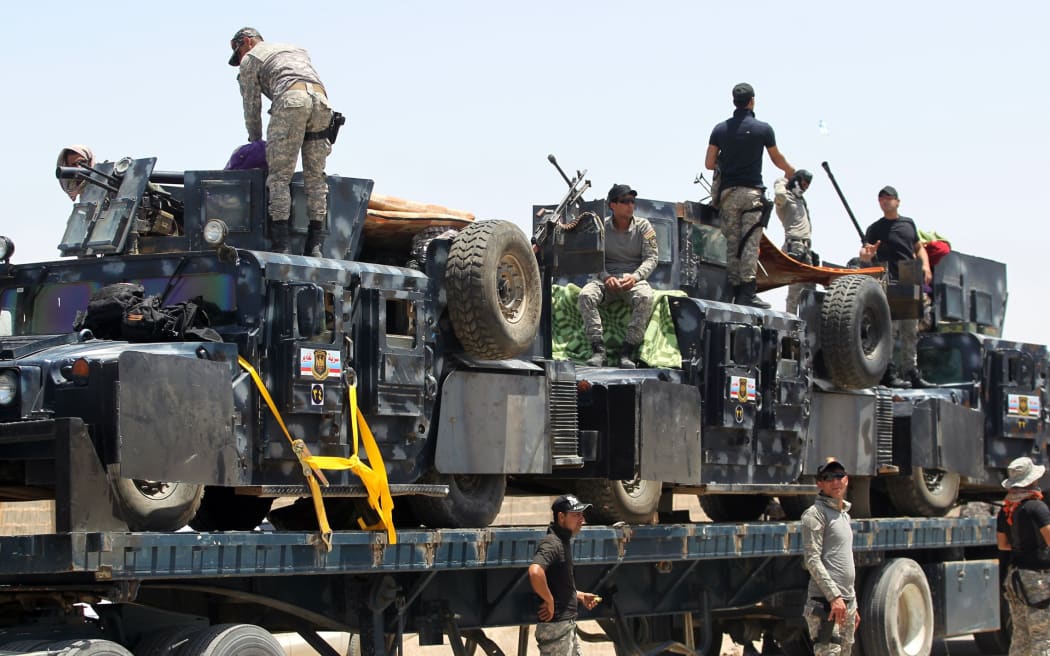 A member of the Iraqi security forces mounts a gun atop a vehicle as they gather on the outskirts of Fallujah as they prepare an operation aimed at retaking the city from the Islamic State (IS) group, on May 22, 2016